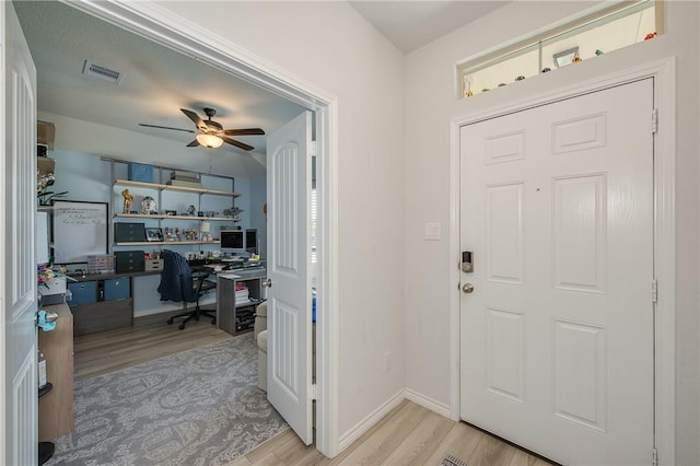 foyer entrance featuring visible vents, baseboards, wood finished floors, and a ceiling fan