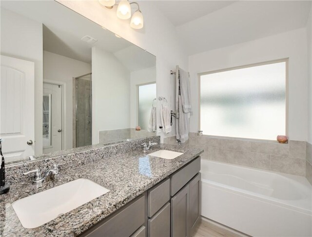 bathroom featuring a sink, visible vents, a bath, and a shower stall