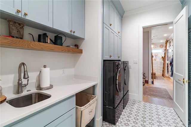 laundry area with crown molding, washer and clothes dryer, cabinet space, a sink, and baseboards