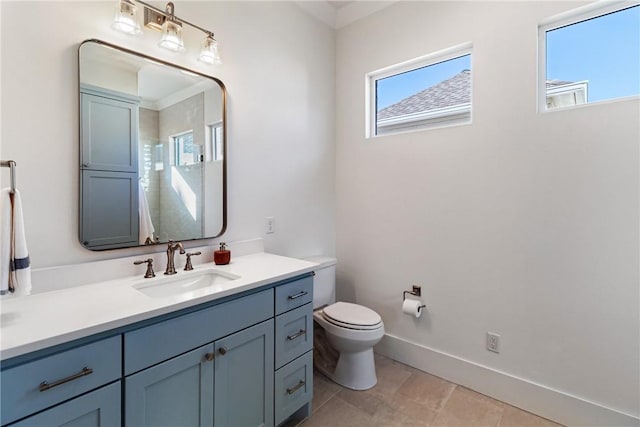 bathroom featuring vanity, toilet, and baseboards