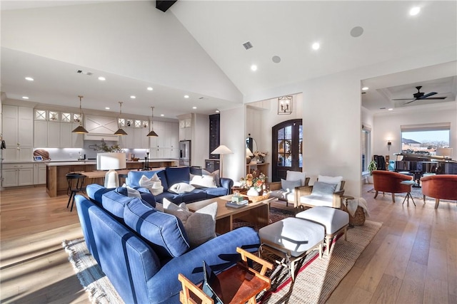 living room with light wood finished floors, recessed lighting, visible vents, ceiling fan, and high vaulted ceiling