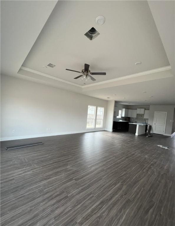 5324 Lyle Pl, Bryan, TX 77807 - unfurnished living room with a raised ceiling, dark wood-type flooring, ceiling fan, and crown molding