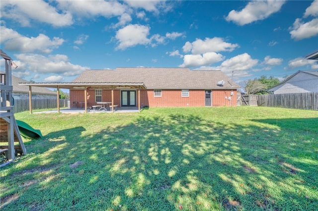 rear view of property with a lawn and a patio area