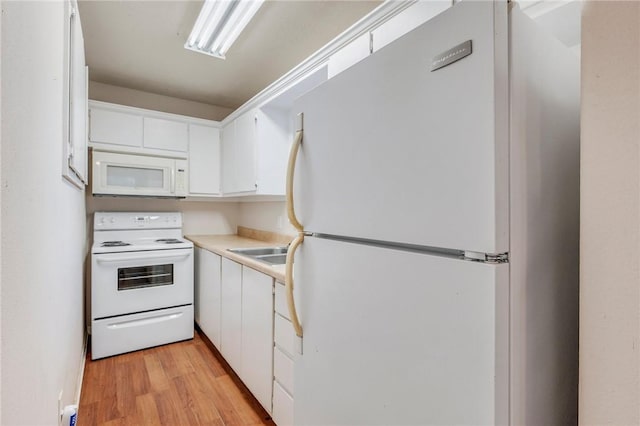 kitchen featuring light countertops, white appliances, white cabinets, and light wood-style flooring