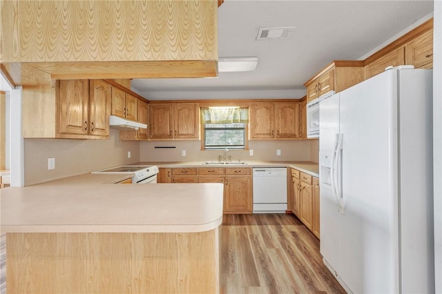 kitchen featuring under cabinet range hood, a peninsula, white appliances, a sink, and visible vents