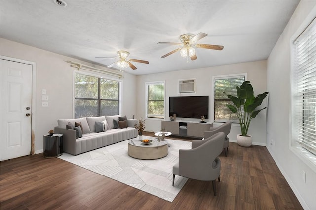 living area with a wall mounted air conditioner, dark wood finished floors, and baseboards