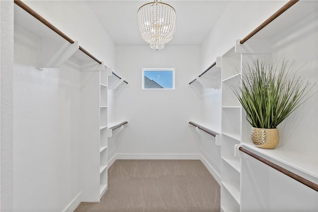 spacious closet featuring an inviting chandelier and light carpet