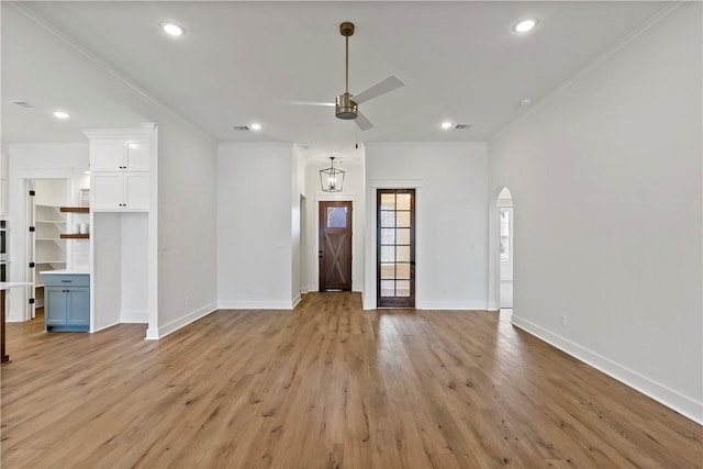 unfurnished living room with crown molding, ceiling fan, and light wood-type flooring