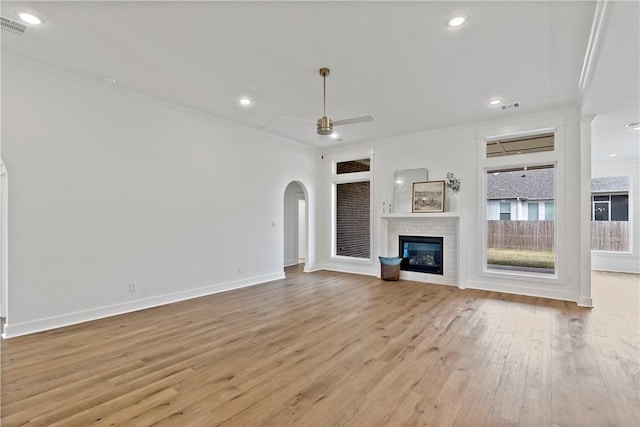 unfurnished living room featuring light hardwood / wood-style flooring, ornamental molding, and ceiling fan