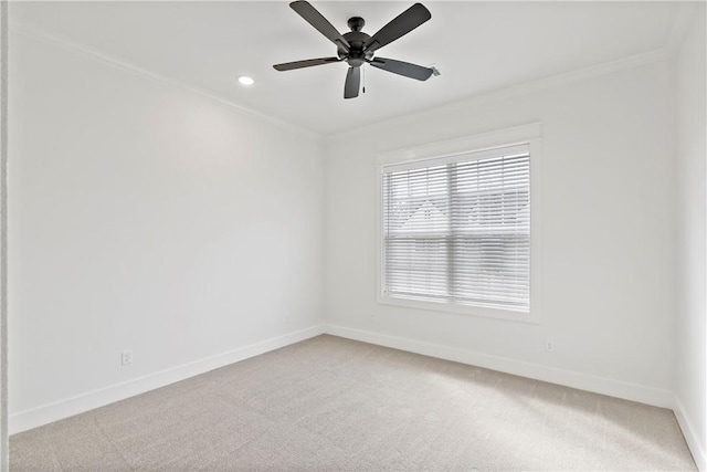 empty room featuring crown molding, light colored carpet, and ceiling fan