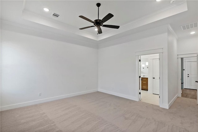 carpeted spare room featuring crown molding, a raised ceiling, and ceiling fan