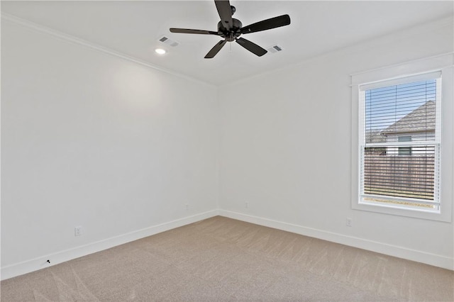 empty room with crown molding, ceiling fan, and light carpet