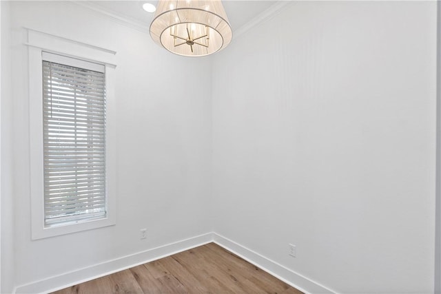 spare room with crown molding, wood-type flooring, and a wealth of natural light