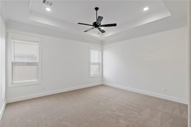 carpeted empty room with crown molding, ceiling fan, and a tray ceiling