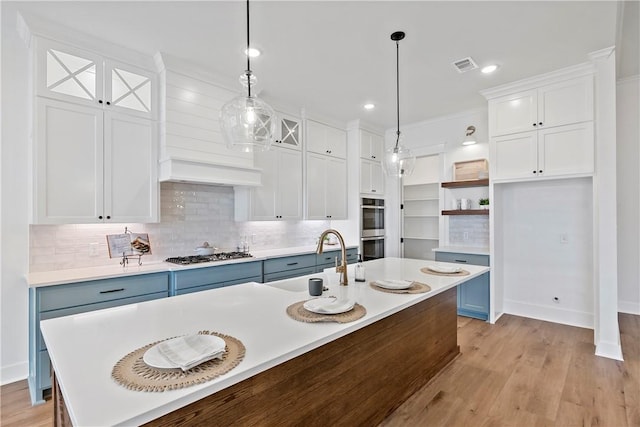 kitchen featuring appliances with stainless steel finishes, sink, pendant lighting, and white cabinets