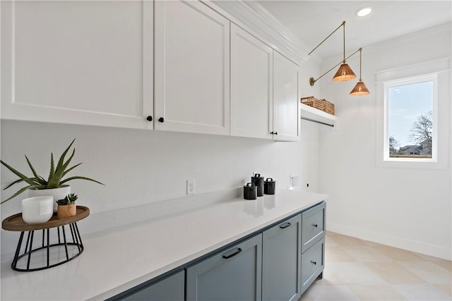 bar with pendant lighting and white cabinets