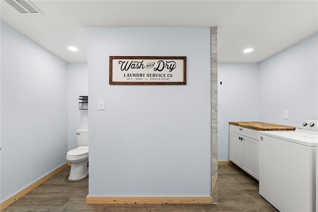 bathroom with toilet, hardwood / wood-style floors, vanity, and washer / dryer