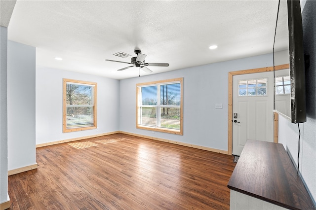 entrance foyer with a textured ceiling, ceiling fan, and dark hardwood / wood-style floors