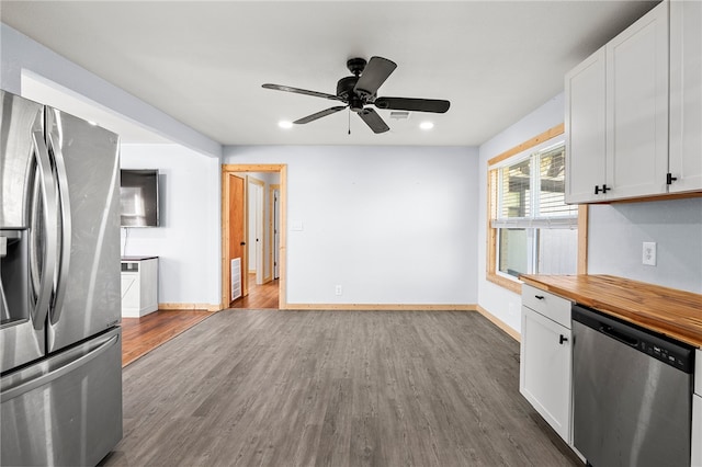 kitchen with appliances with stainless steel finishes, white cabinetry, ceiling fan, and wood-type flooring