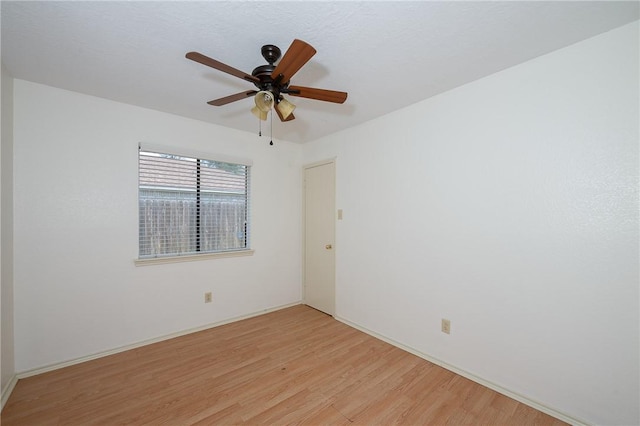 spare room with light wood-type flooring and ceiling fan