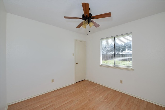 empty room with a ceiling fan, light wood-type flooring, and baseboards