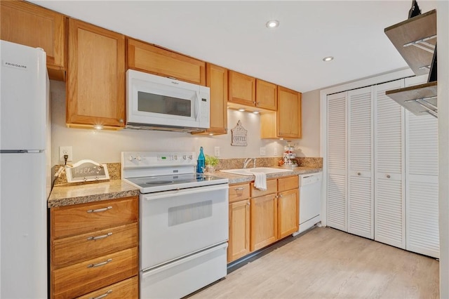 kitchen with sink, white appliances, and light wood-type flooring