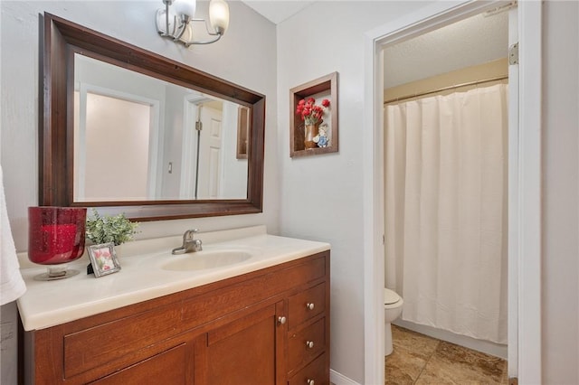 bathroom with an inviting chandelier, vanity, and toilet