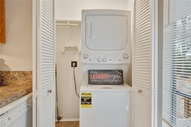 laundry room featuring light hardwood / wood-style flooring and stacked washer and clothes dryer