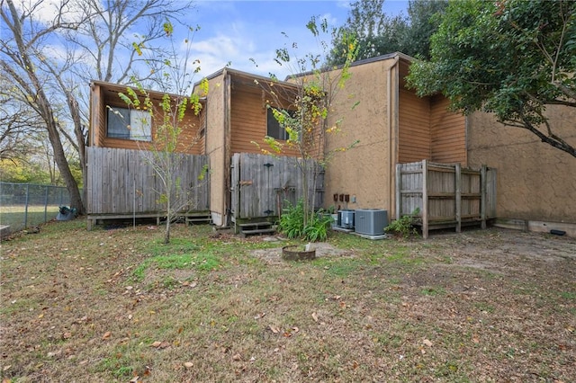 rear view of property with central AC