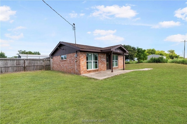 rear view of house with a yard and a patio area