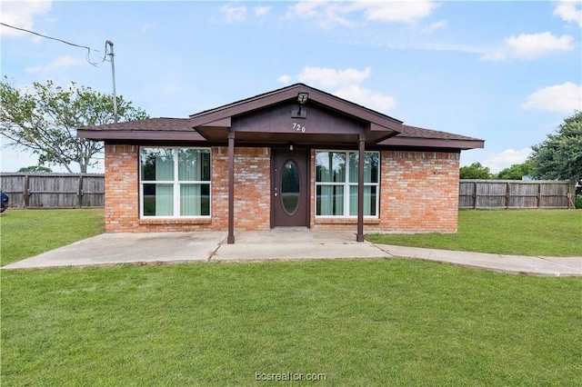 rear view of property featuring a patio area and a yard