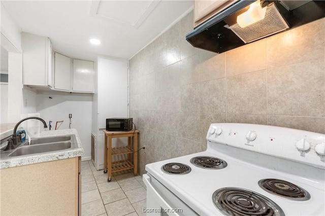 kitchen with sink, light tile patterned floors, range hood, white range with electric cooktop, and white cabinets