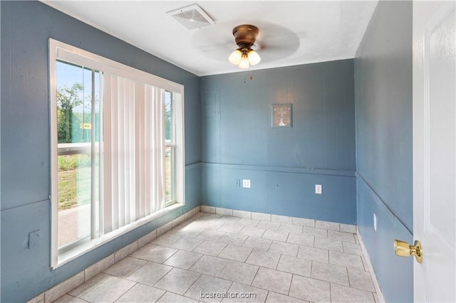 tiled spare room with ceiling fan