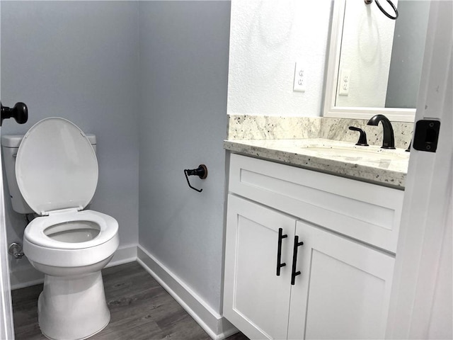 bathroom with vanity, hardwood / wood-style flooring, and toilet