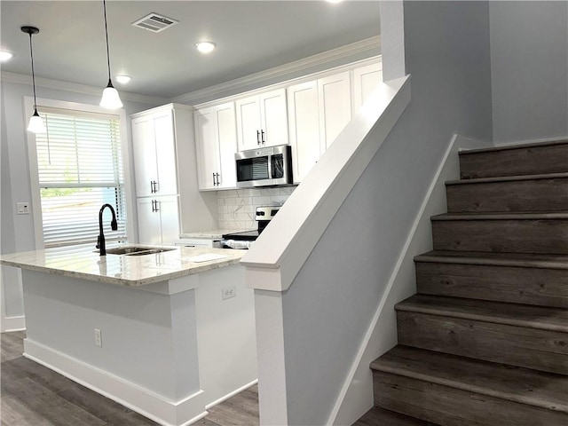 kitchen featuring sink, decorative light fixtures, decorative backsplash, white cabinets, and appliances with stainless steel finishes