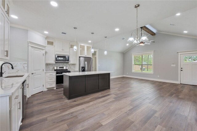 1410 Rochester St, Bryan, TX 77803 - kitchen with appliances with stainless steel finishes, a kitchen island, dark wood-style floors, tasteful backsplash, and white cabinets