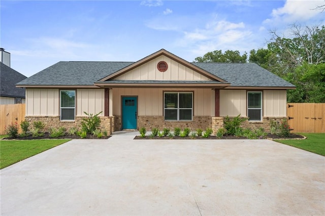 1410 Rochester St, Bryan, TX 77803 - view of front facade with roof with shingles, board and batten siding, and brick siding