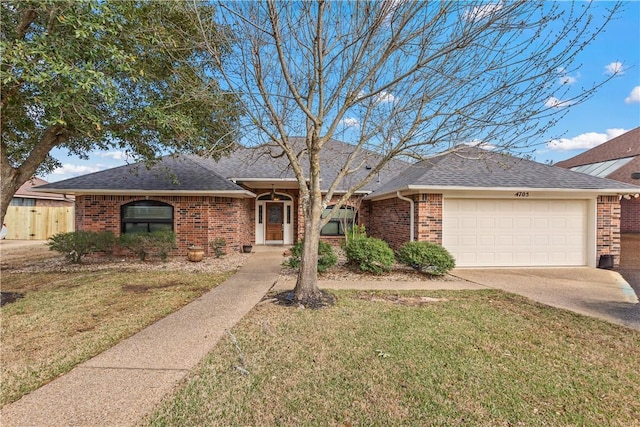 ranch-style home featuring brick siding, an attached garage, and a front yard