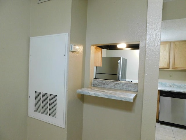 kitchen featuring light brown cabinets, light tile patterned floors, and appliances with stainless steel finishes