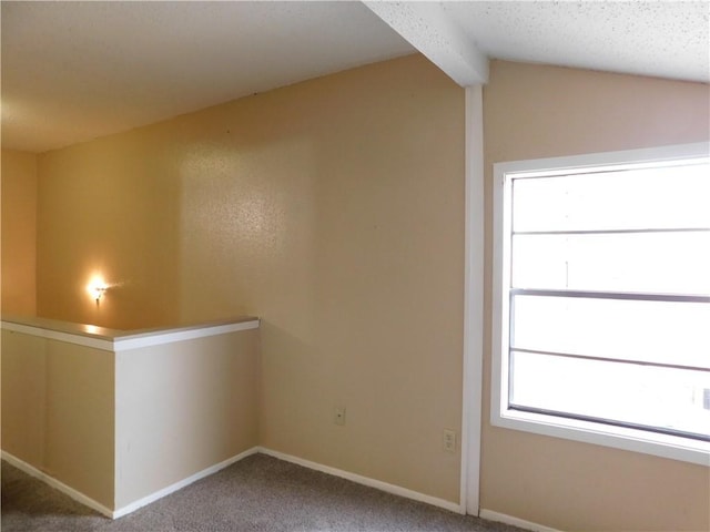 carpeted spare room with lofted ceiling with beams