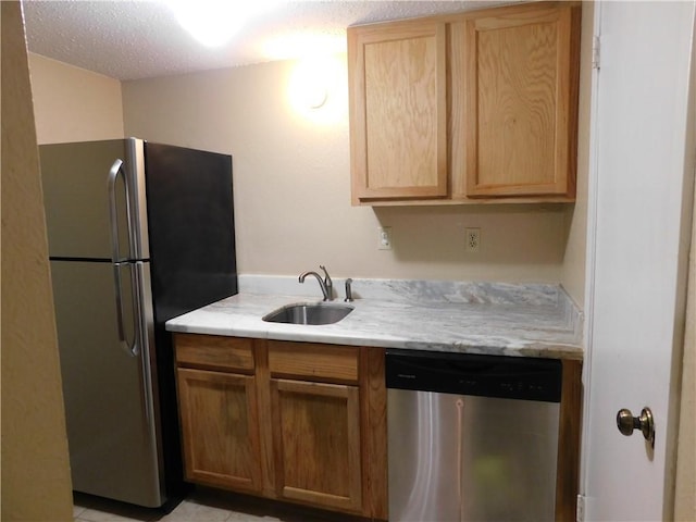 kitchen with a textured ceiling, light tile patterned flooring, sink, and appliances with stainless steel finishes