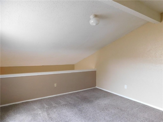 empty room with carpet and lofted ceiling with beams