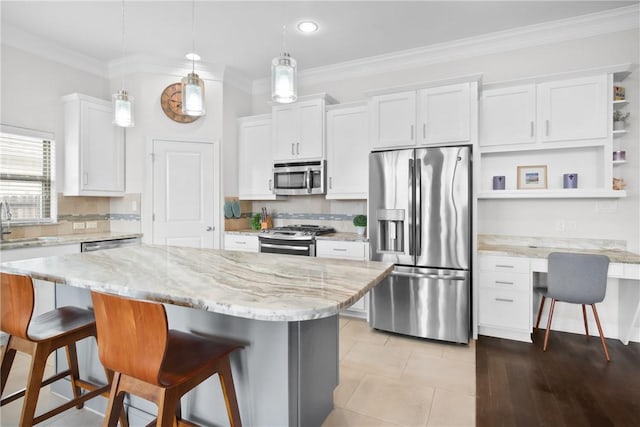 kitchen featuring white cabinetry, a center island, pendant lighting, and appliances with stainless steel finishes