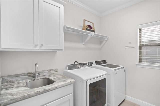 laundry area with cabinets, washing machine and dryer, ornamental molding, and sink