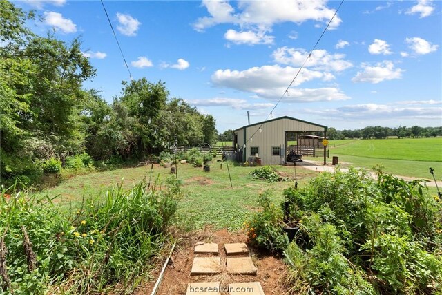 view of yard featuring a rural view and an outdoor structure