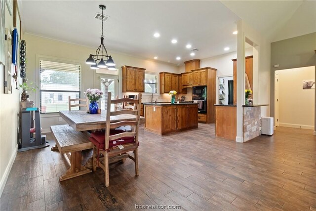 dining space featuring sink, dark hardwood / wood-style flooring, crown molding, and a chandelier