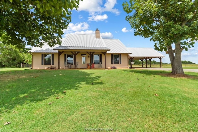 back of property with a lawn and a carport