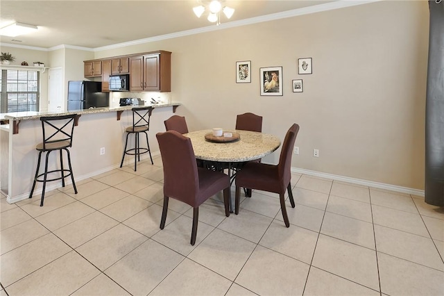 dining area featuring ornamental molding and light tile patterned floors