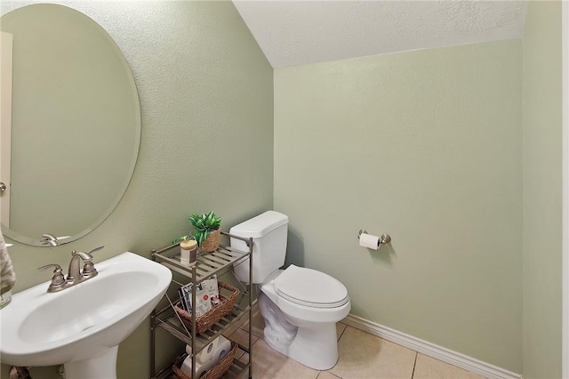 bathroom with sink, toilet, and tile patterned floors