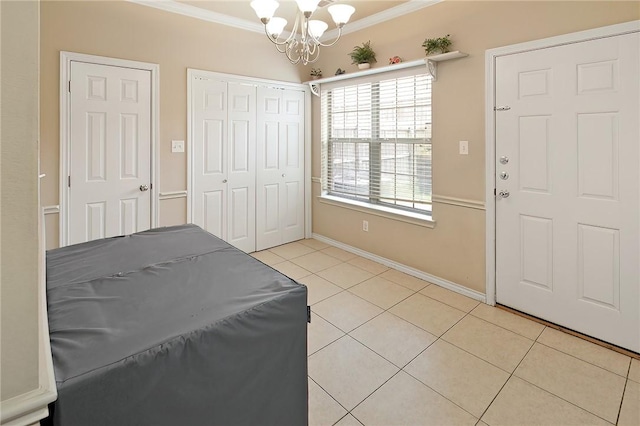 tiled entryway featuring a notable chandelier and ornamental molding